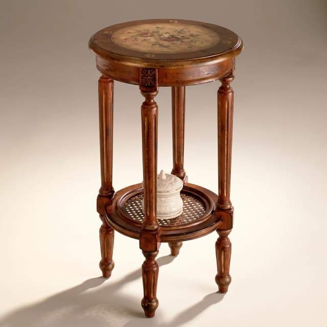 A round, teak wood side table with cane detailing, showcasing a Victorian-style design.