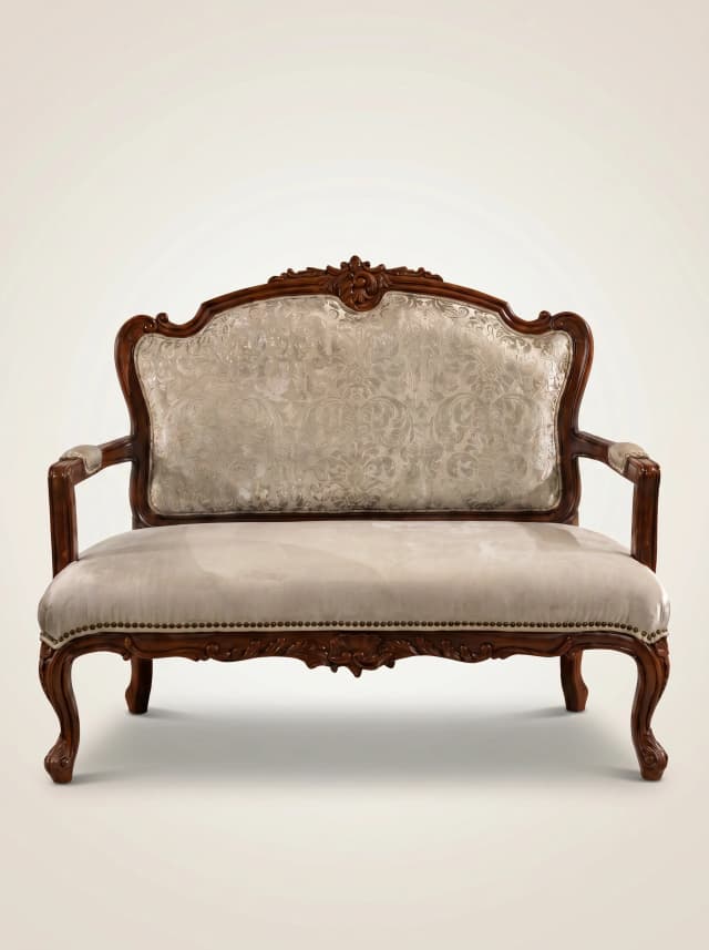 Azure Crevice Sofa with rich, carved teak wood details and plush upholstery.